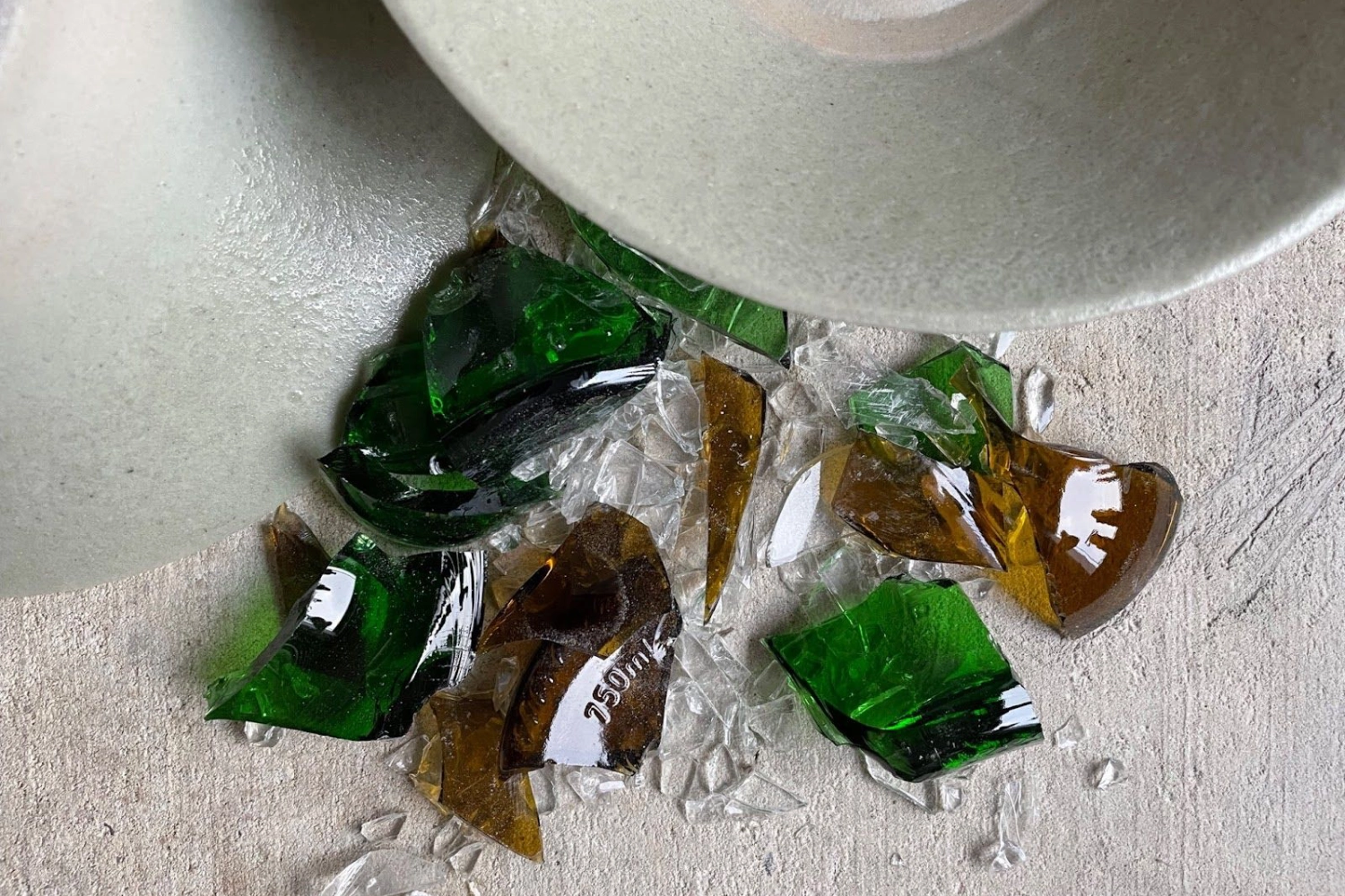 Ceramic bowl glazed with recycled glass from the Ødeland project, with glass waste used in the glaze beside it